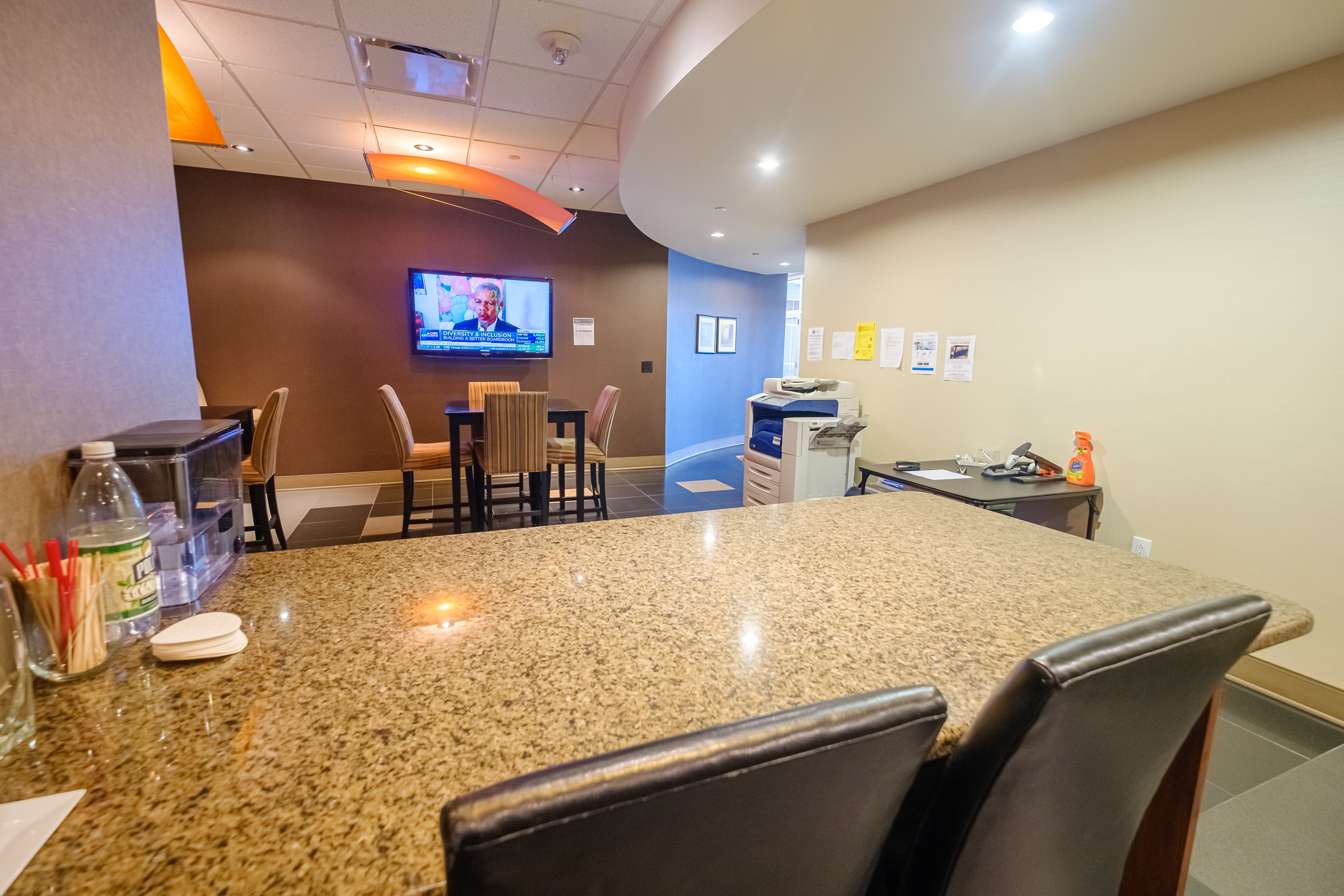 OSS Kitchen Wells Fargo Center. Common area with several tables and kitchenette. Copier to the side.