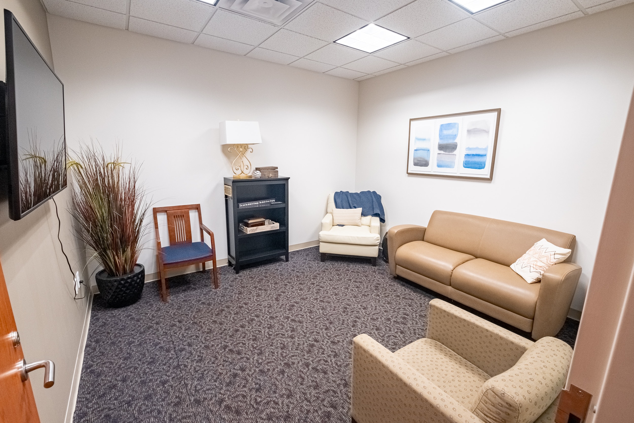 OSS Headquarters Waiting Room. Comfortable looking room with various seating, plant, TV and reading material shelf.