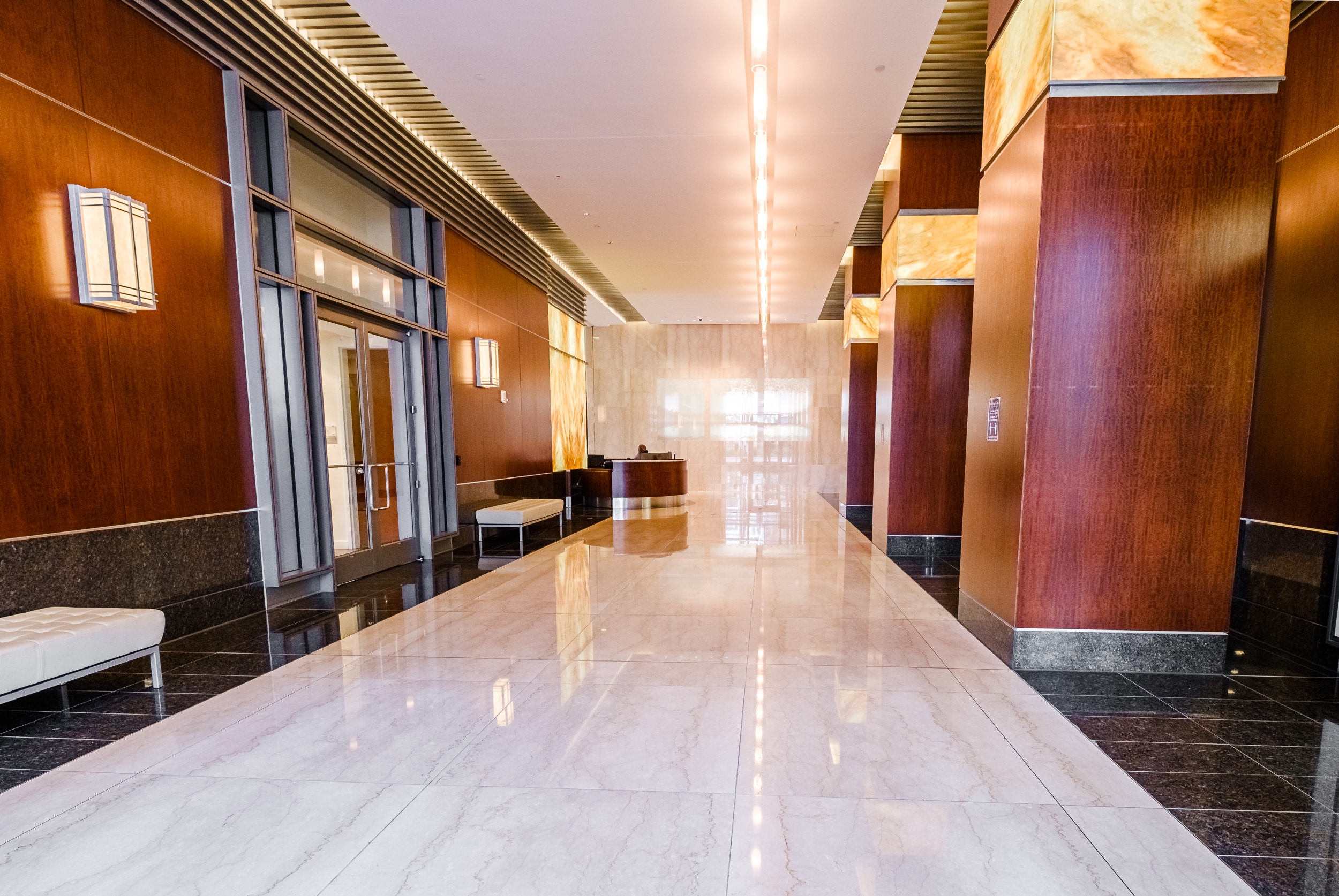 OSS Wells Fargo Center Lobby. Large and brightly-lit main lobby of building with stone floors and modern decor.